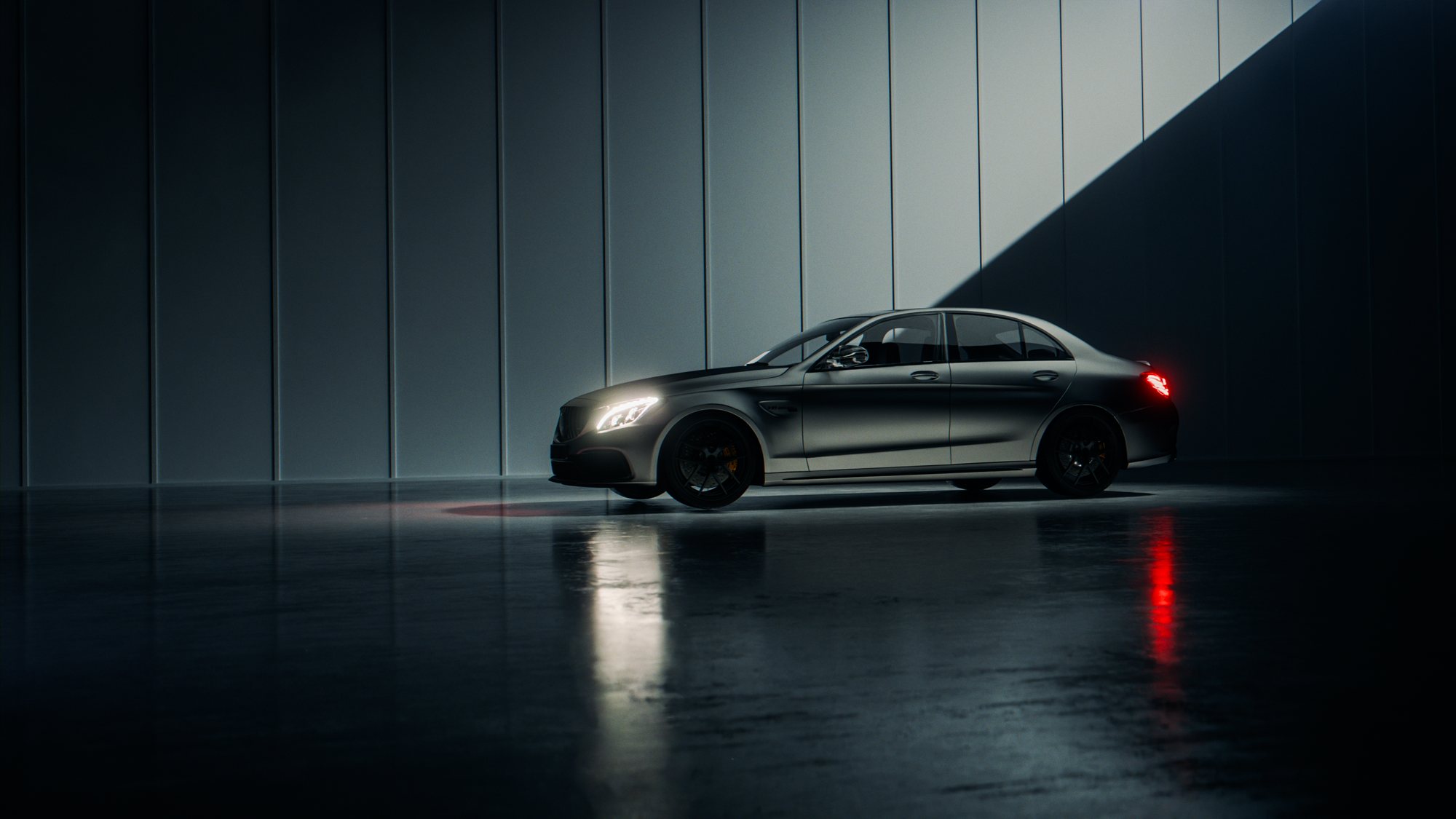 C 63 with headlights on in a dark concrete underpass