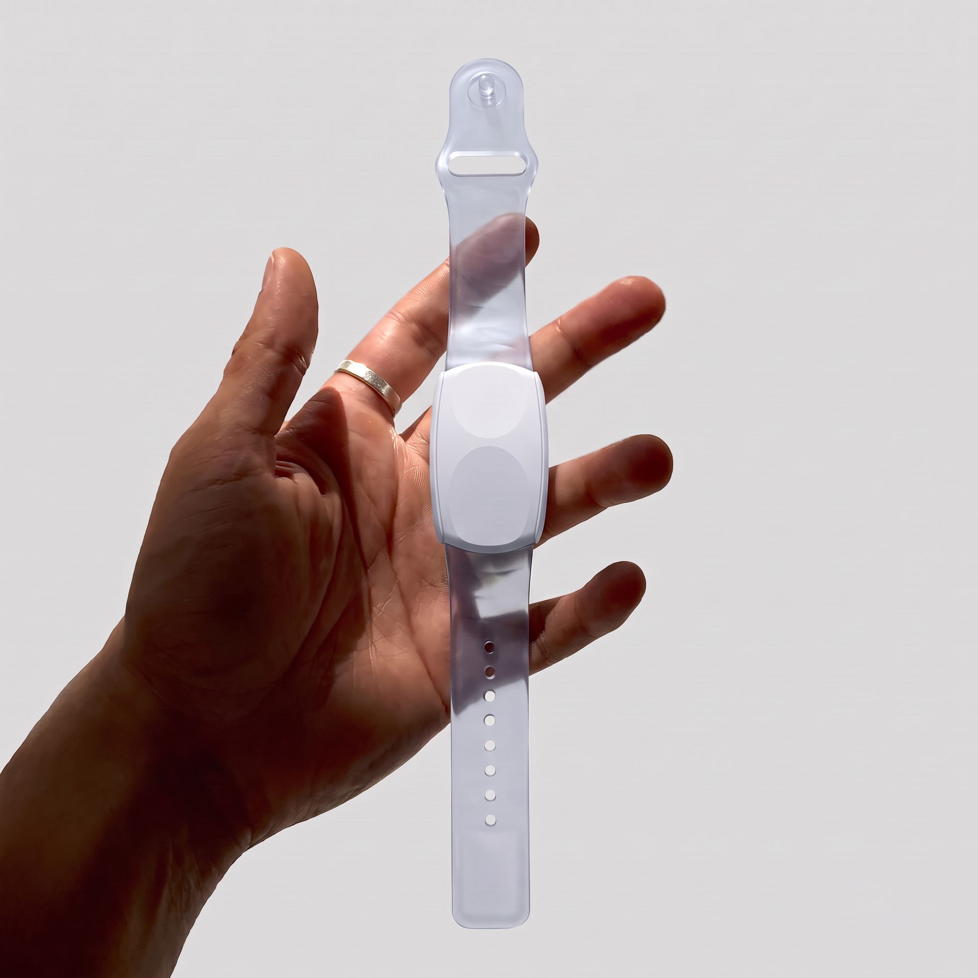 Hand holding the bracelet by its translucent strap