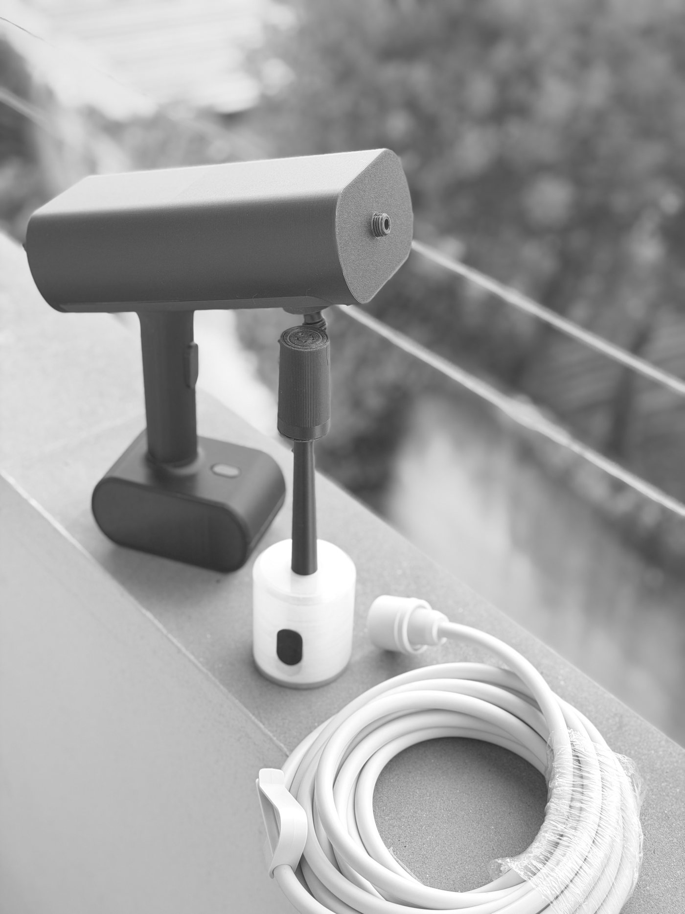 The printed Nami prototype on a balcony ledge with its hose