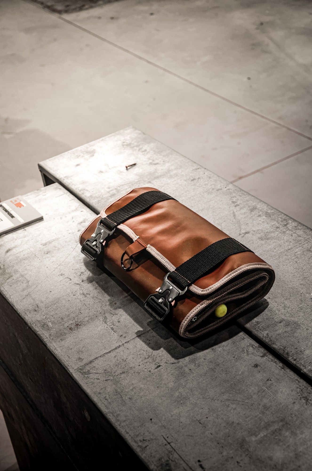 Nomad Shift rolled up and closed with two Cobra buckles on a concrete bench